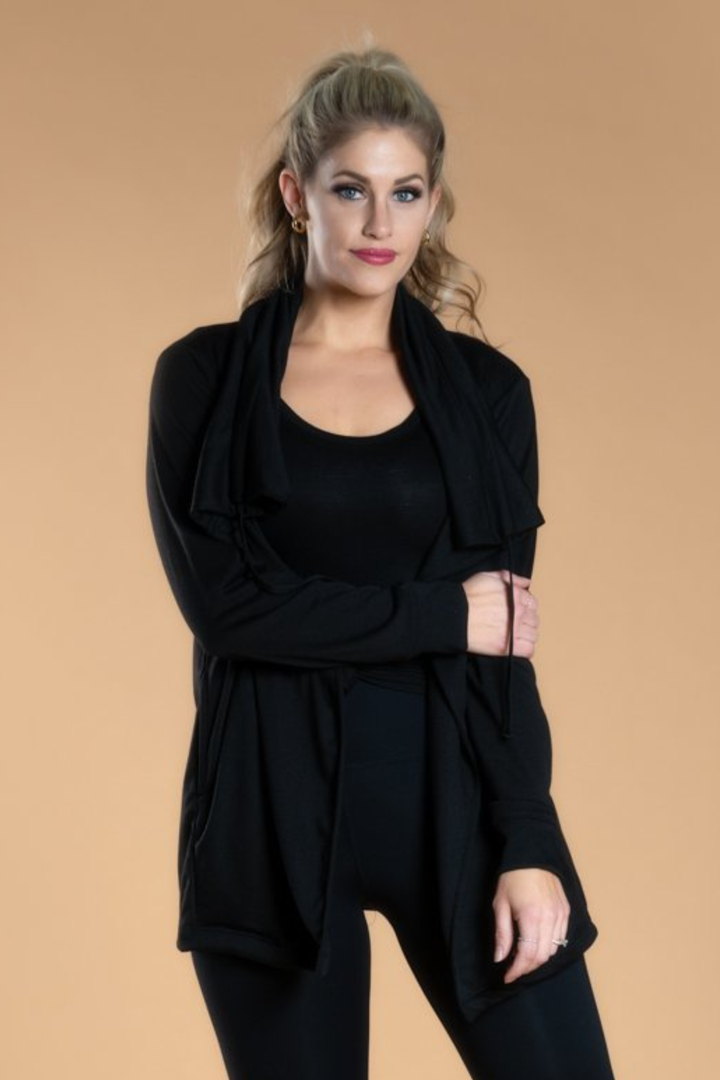 Woman wearing a black outfit against a beige background